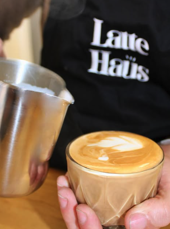 Barista pouring latte art at Latte Haus