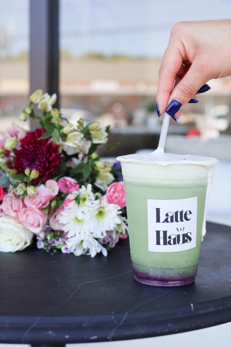Matcha latte with flowers on black table at Latte Haus