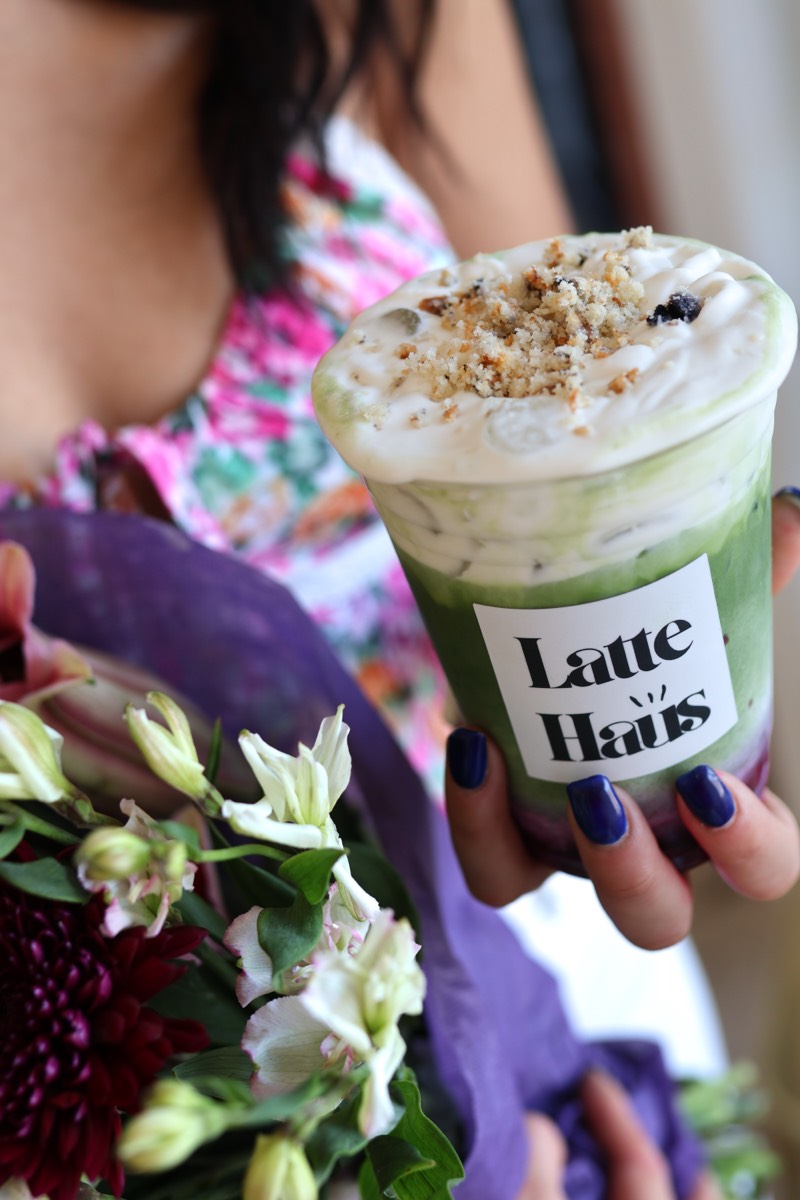 Blueberry matcha held with flower bouquet at Latte Haus